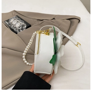 Detail of floral round bag with pearl handle and three-dimensional leather petals