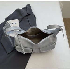 Detail of silver metallic hobo bag showing brown fabric lining and inner zipper pocket