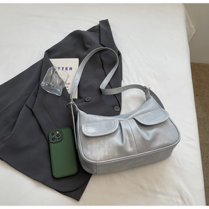 Close-up of silver metallic dumpling bag with pleat texture and small side pockets