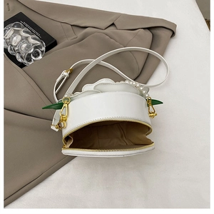 Detail of white round floral bag with petal decor, pearl handle and gold zipper closure