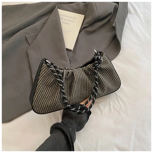 Close-up of woven dumpling bag with pleated cloud design and spiral rope shoulder strap