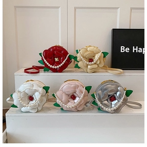 Detail of floral evening handbags in multiple colors with pearl straps and 3D petals