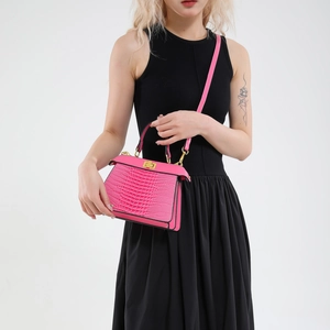 Pink crocodile-embossed leather handbag with gold twist-lock and detachable strap