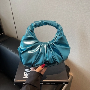 Metallic blue pleated wristlet bag with French luxury style and croissant-shaped design