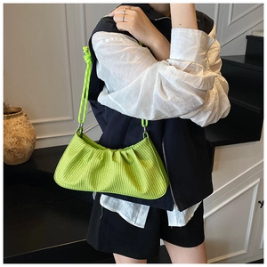 Detail of neon green woven dumpling bag with pleated texture and thick rope strap