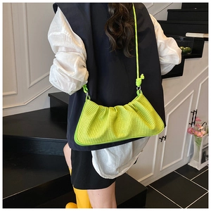 Detail of lime green woven dumpling bag with knot shoulder strap on minimalist stairs
