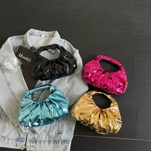 Chic metallic pleated wrist bags in black, blue, magenta and gold on a flatlay setup