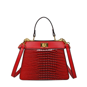 Elegant red crocodile texture handbag with golden hardware clasp and crossbody strap