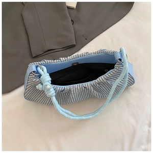 Detail of blue and white checkered cloud bag showing interior liner and magnetic buckle