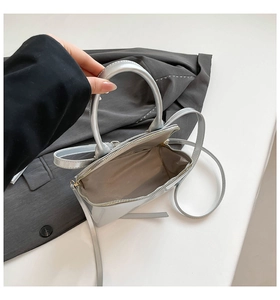 Detailed interior view of a silver metallic shell bag with smooth fabric lining