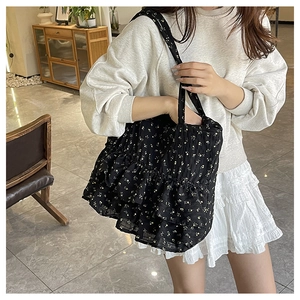Detail of black floral tote bag with layered ruffles and large capacity design