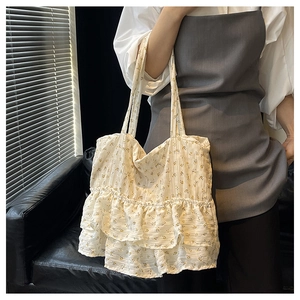 Detail of floral tote bag featuring layered ruffle trim and delicate yellow flower patterns