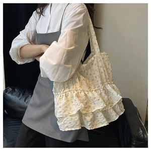 Detailed view of cream floral tote bag featuring triple ruffle design and wide shoulder strap