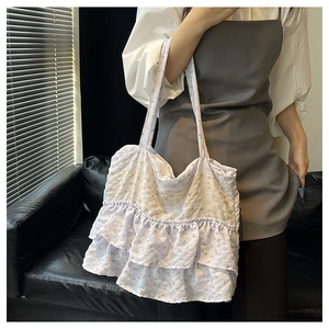 Detailed view of large floral tote bag with layered ruffle design and textured fabric