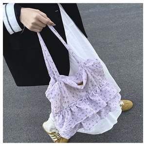 Detail of purple floral tote bag featuring tiered ruffle layers and lightweight fabric