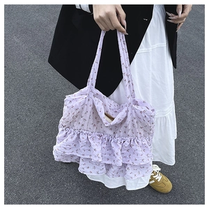 Detail of light purple floral tote bag with elegant layered ruffles and slim handles
