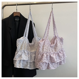 Detail of floral fabric tote bags with ruffled edges in light blue and pink pastel colors