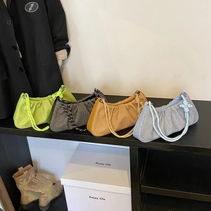 Pleated underarm cloud bags in green, yellow, and blue displayed on a shelf