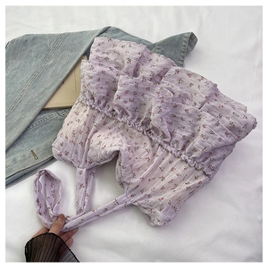 Close-up of floral ruffle tote bag with lavender pattern and textured fabric surface