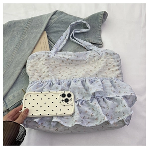 Detail of floral canvas tote bag featuring ruffled layers and a mobile phone size reference