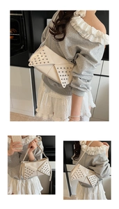 Détails macro d'un sac à bandoulière punk blanc avec rivets métalliques et doubles rabats
