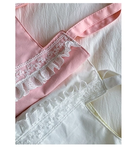 Detailed view of delicate white lace embroidery and ruffled edges on canvas tote bag