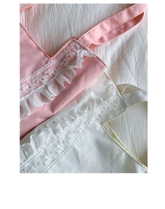 Close-up of delicate hollow-out embroidery lace and ruffled edges on canvas tote bags