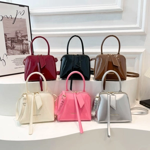Glossy patent leather dome handbags in multiple colors featuring elegant hanging tassel
