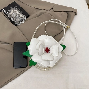 White flower shaped shoulder bag with pearl decor and adjustable strap on neutral clothes