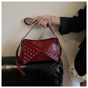 Détail d'un sac moto rouge en cuir brillant orné de rivets argentés métalliques