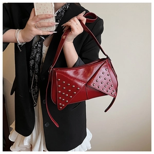 Détail du sac bandoulière rouge géométrique avec rivets argentés et finition brillante
