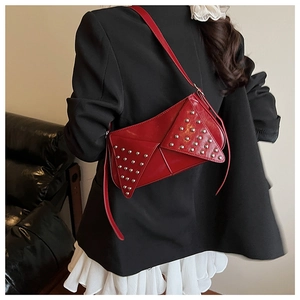 Detail of red punk-style shoulder bag with silver rivets and geometric stitching