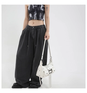 Close-up of wide-leg dark grey denim cargo pants with adjustable drawstring waist details
