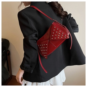 Détail du sac bandoulière rouge en similicuir avec clous argentés et rabat triangulaire