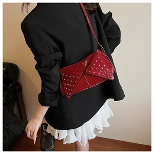 Gros plan sur un sac moto en cuir verni rouge avec des rivets argentés brillants