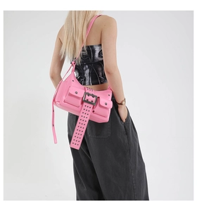 Macro detail of pink punk shoulder bag with rivets and oversized silver metal buckle