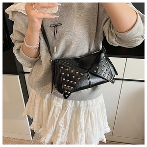 Detail of a black punk underarm bag with silver rivets and glossy PU leather finish
