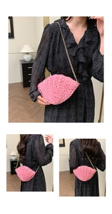 Detail of pink woven shell-shaped crossbody bag with gold chain and hollow texture