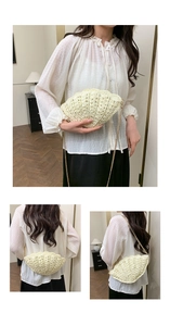 Detail view showing woven shell texture and gold chain on beige straw crossbody bag