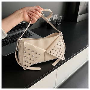 Détail du sac à bandoulière en similicuir blanc crème avec rivets punk argentés