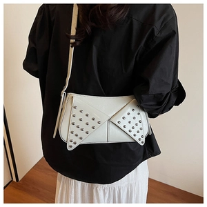 Détail du sac à bandoulière crème avec rivets et rabat en forme d'aile unique