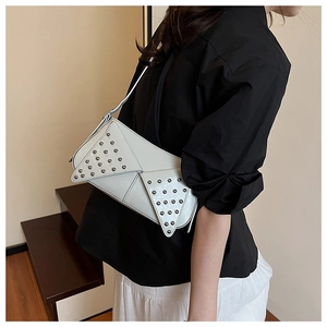 Detail of white punk style baguette bag with silver rivet studs on collar flap