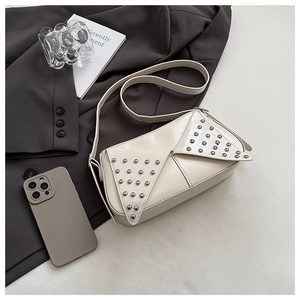 Détail du sac en similicuir blanc crème avec clous argentés et bandoulière réglable