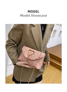 Detail of pink quilted leather bag with golden heart buckle and tassel on shoulder