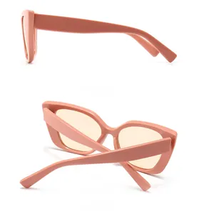 Detail view of pink cat-eye sunglasses featuring wide temples and sleek salmon frames