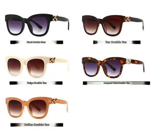 Cinq lunettes de soleil carrées avec décor papillon en strass présentées sur fond blanc