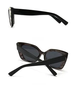 Detailed side profile and hinge of thick black cat-eye sunglasses with dark grey lenses