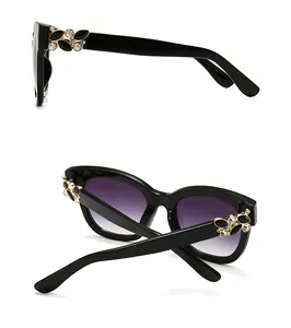 Gros plan de lunettes noires avec verres dégradés violets et détails en cristal ciselé