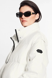 Close-up of black square frame sunglasses with luxury gold logo detail on the temple