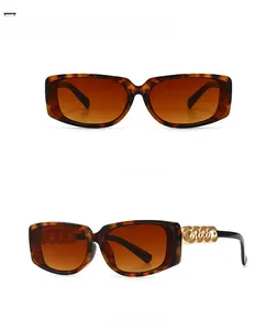 Detail of leopard print sunglasses featuring bold gold chain links on the temples